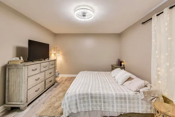 a bedroom with a bed and a flat tv screen on a dresser