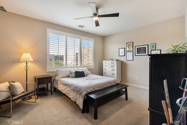 a bedroom with a bed flat screen tv closet and a lamp