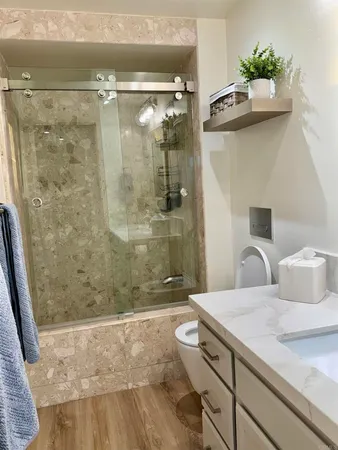 a bathroom with a sink a toilet and shower