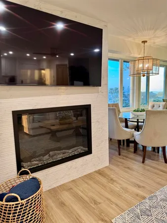 a living room with stainless steel appliances furniture a rug and a view of living room