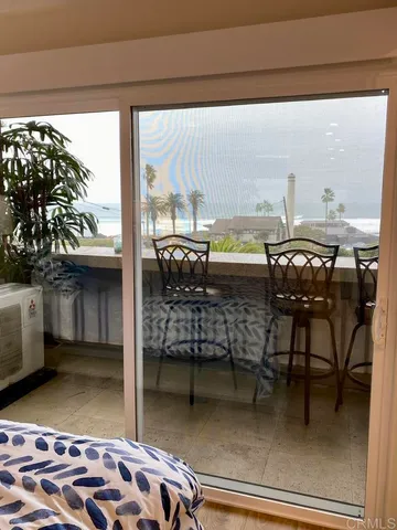 a dining room with furniture and a floor to ceiling window