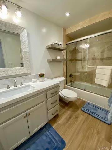 a bathroom with a double vanity sink toilet mirror and shower