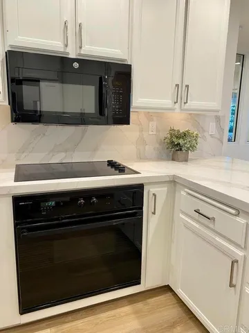 a kitchen with granite countertop cabinets stove and microwave