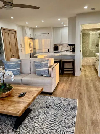 a bathroom with a granite countertop sink a toilet a mirror and bathtub