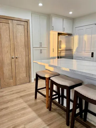 a view of a bedroom with wooden floor and furniture