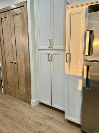 a bedroom with a bed a dresser with wooden floor