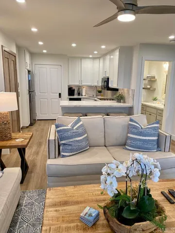 a living room with furniture kitchen view and a chandelier