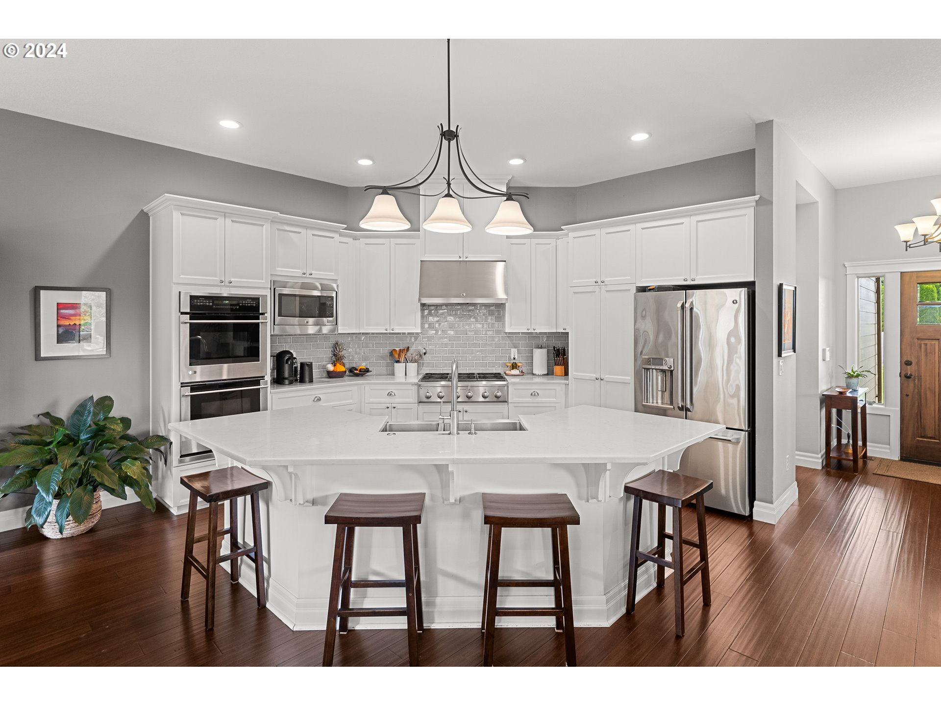 25595 South Rhoten Road Aurora, OR 97002 - Photo 16 of 48 a kitchen with stainless steel appliances granite countertop a stove a refrigerator a microwave a dining table and chairs with wooden floor
