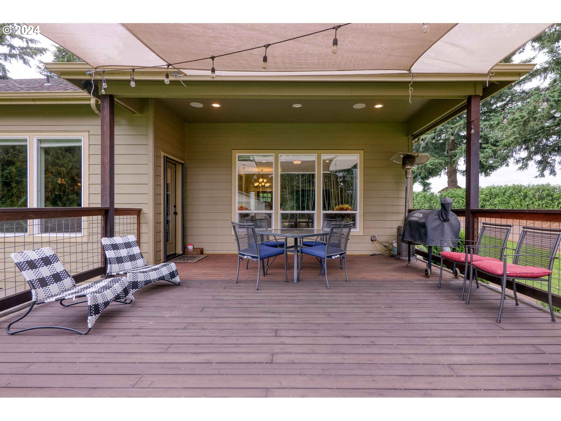 25595 South Rhoten Road Aurora, OR 97002 - Photo 21 of 48 a view of a patio with table and chairs with wooden floor and fence