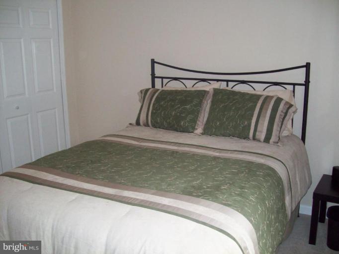 603 Pasture Brook Road Severn, MD 21144 - Photo 17 of 22 a bed sitting in a bedroom next to a window