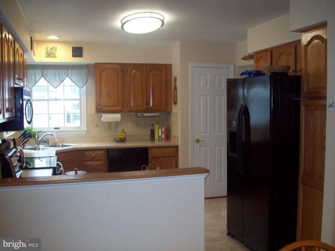 603 Pasture Brook Road Severn, MD 21144 - Photo 7 of 22 a kitchen with stainless steel appliances granite countertop a refrigerator and a sink