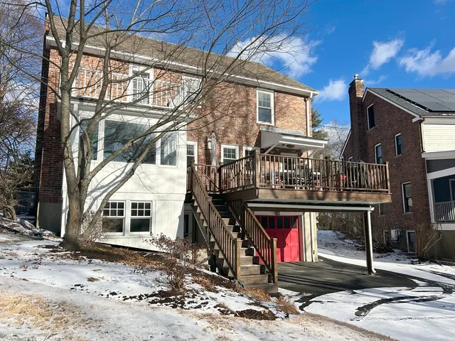 a view of a blue house with snow on the road