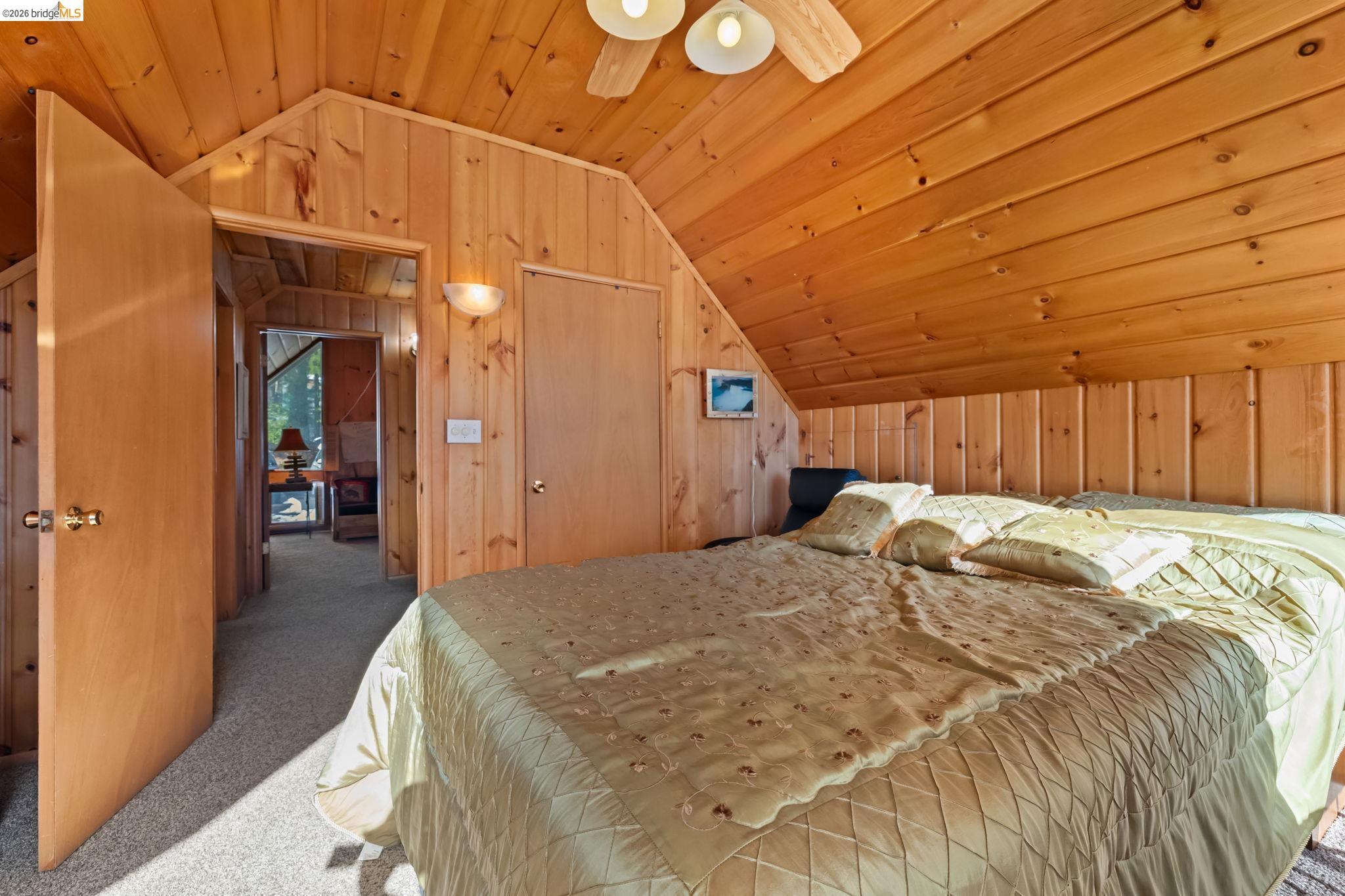 26039 Long Barn Road Long Barn, CA 95335 - Photo 20 of 27 Bedroom featuring lofted ceiling, wooden ceiling, wood walls, carpet floors, and ceiling fan
