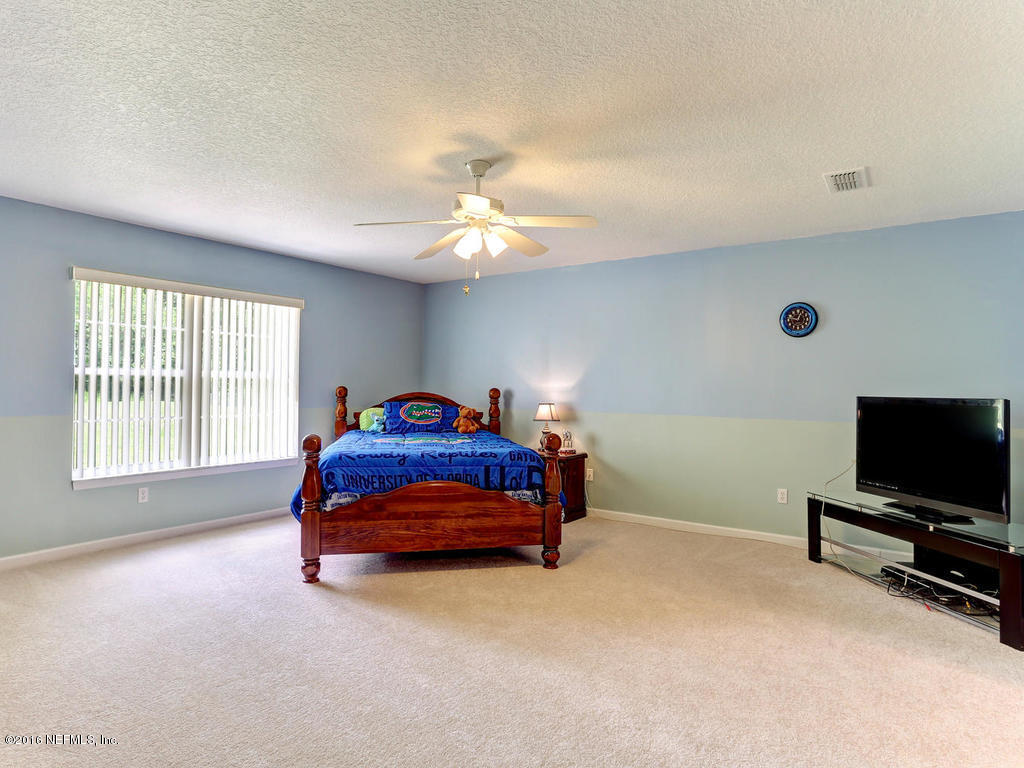 45227 Stratton Road Callahan, FL 32011 - Photo 24 of 42 a bedroom with a bed and a flat screen tv