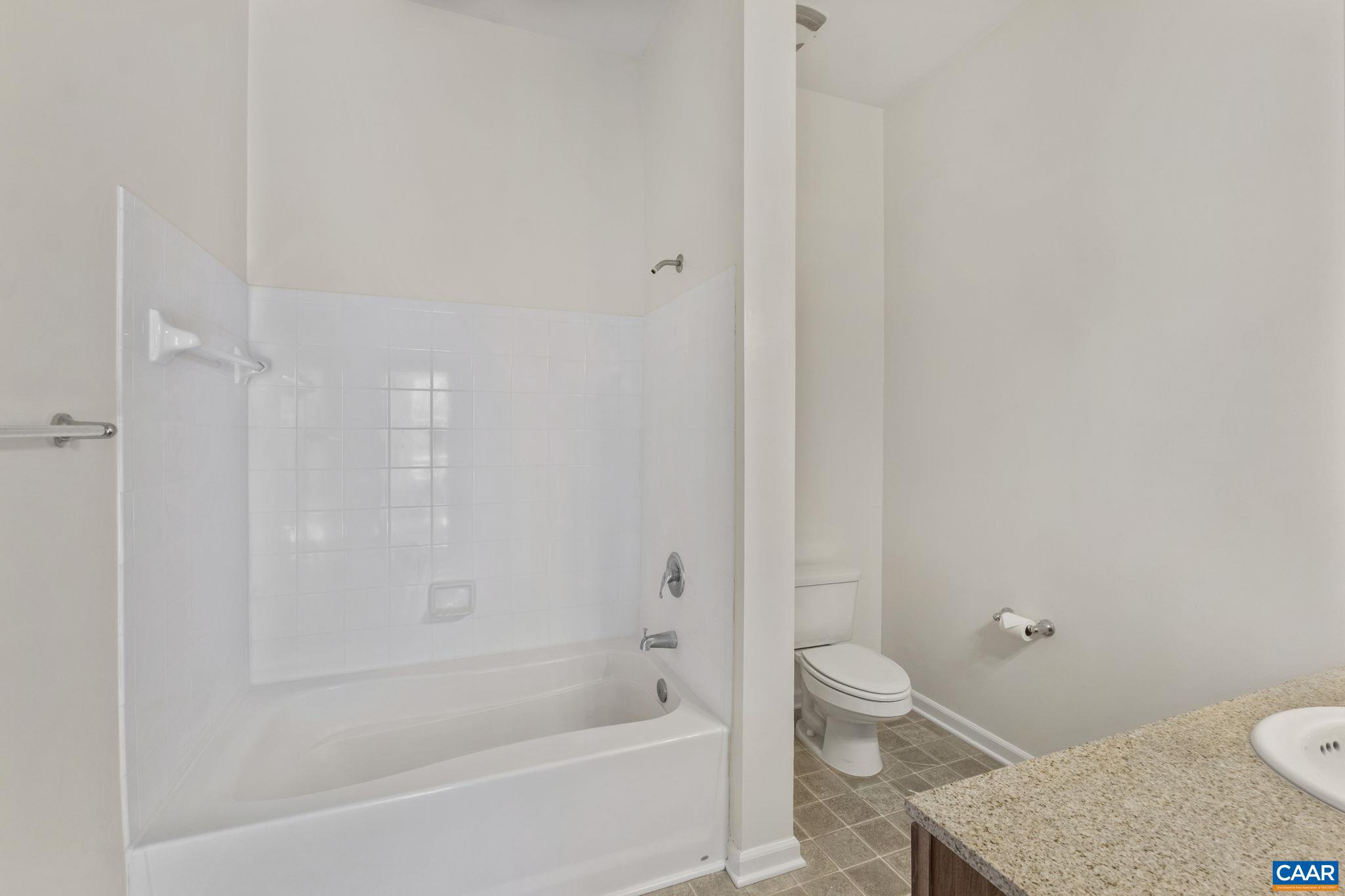 765 Walker Square, Unit 4B Charlottesville, VA 22903 - Photo 13 of 17 a bathroom with a granite countertop toilet a sink and bathtub