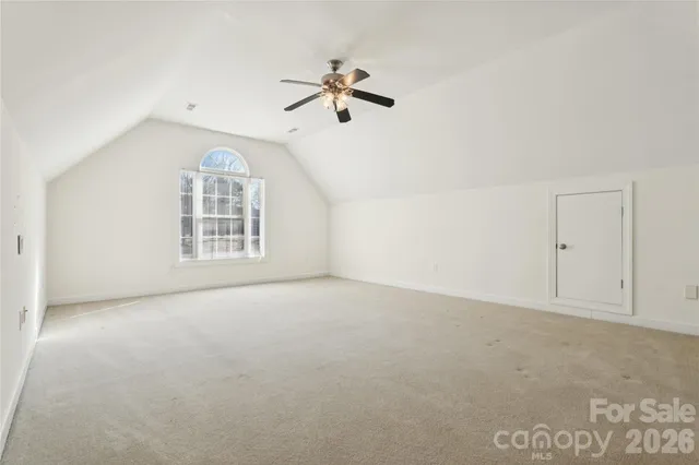 an empty room with windows and ceiling fan