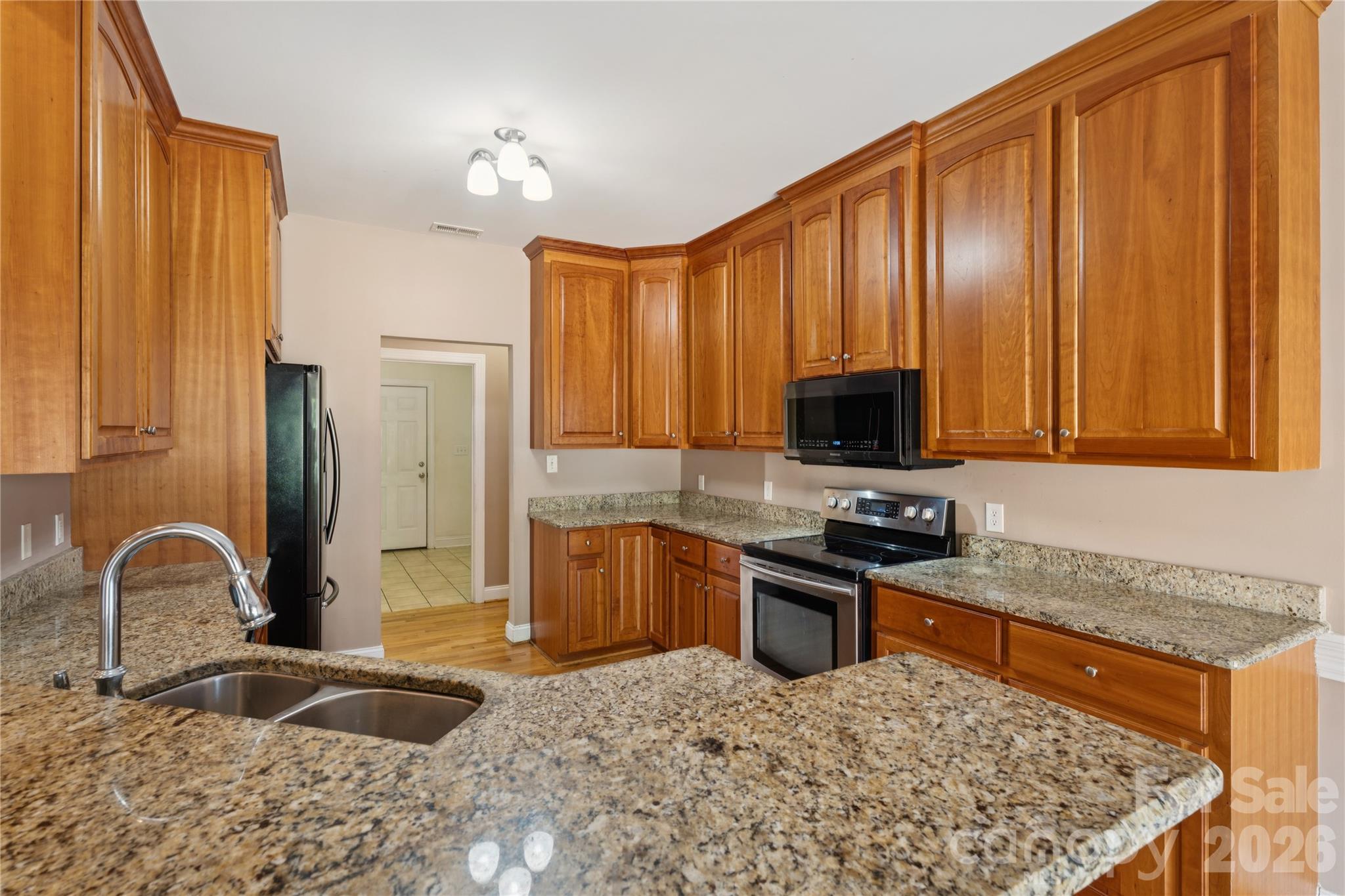 1308 Kerrington Way Clover, SC 29710 - Photo 6 of 33 a kitchen with stainless steel appliances granite countertop a stove a sink and a microwave