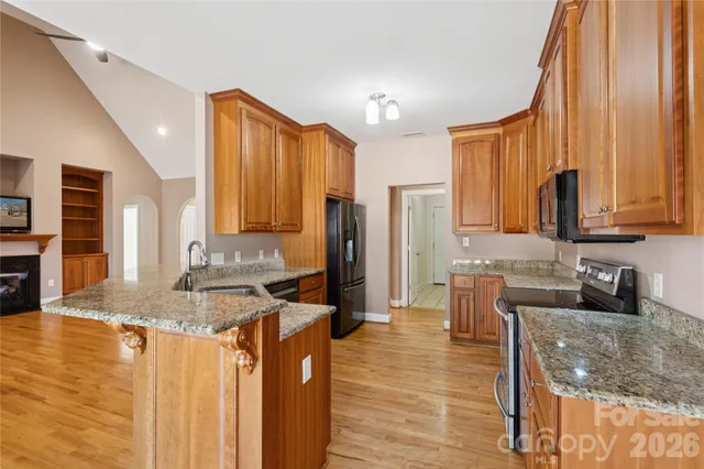 a kitchen with granite countertop a sink a counter top space and cabinets