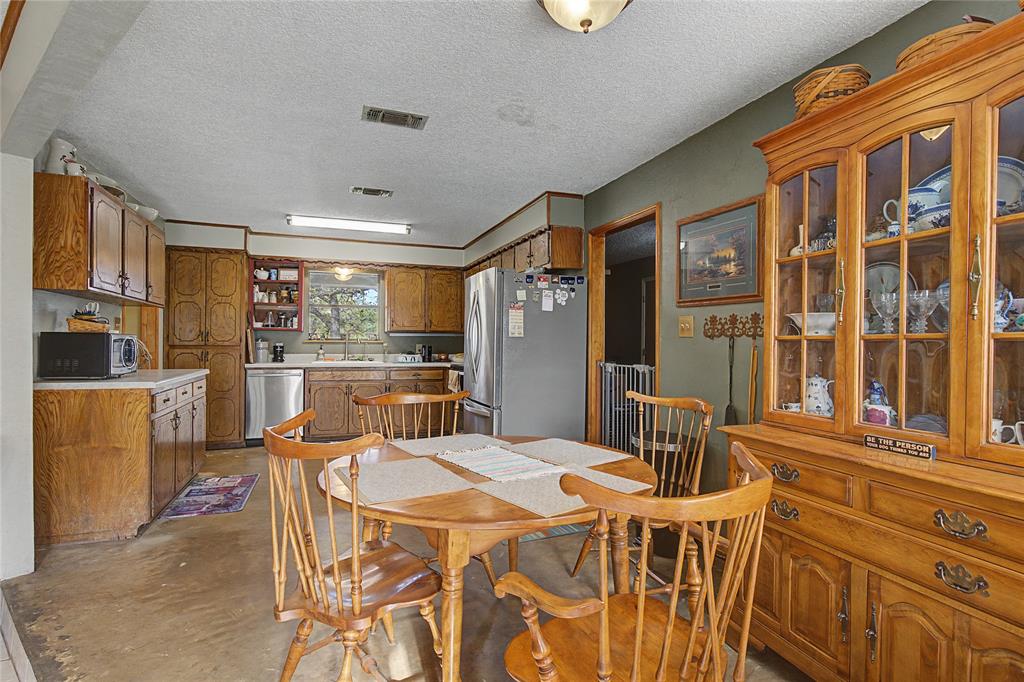 243 County Road 3851 Poolville, TX 76487 - Photo 11 of 34 a dining room with furniture a window and kitchen view