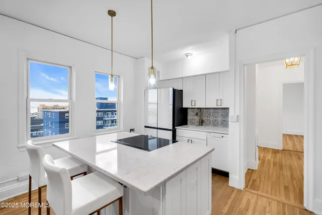 a kitchen with stainless steel appliances granite countertop a sink a refrigerator and a stove