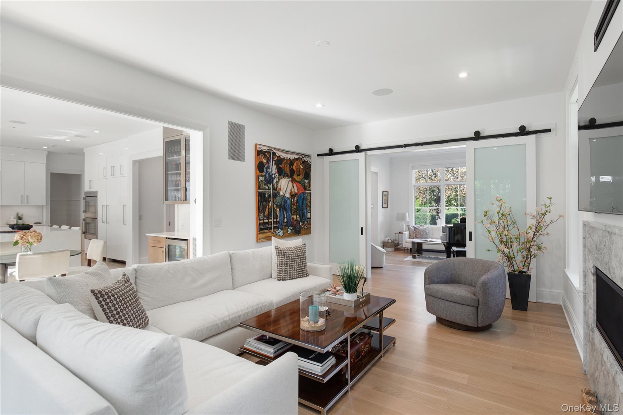 16 Myrtledale Road Scarsdale, NY 10583 - Photo 12 of 48 Spacious family room featuring a barn door, fireplace opens to the kitchen and also offers access to the living room