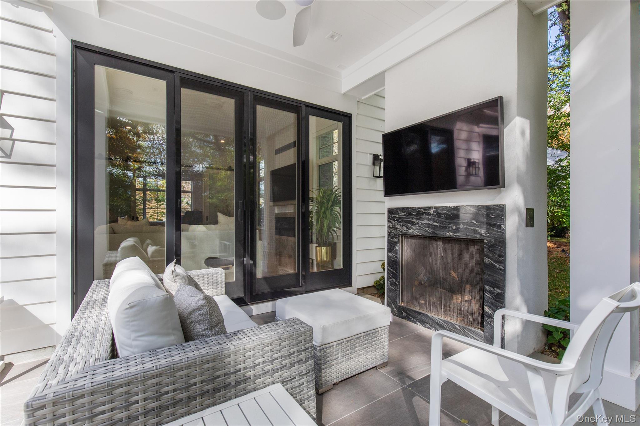 16 Myrtledale Road Scarsdale, NY 10583 - Photo 23 of 48 Covered porch with gas fireplace, ceiling speakers, outdoor tv and fan