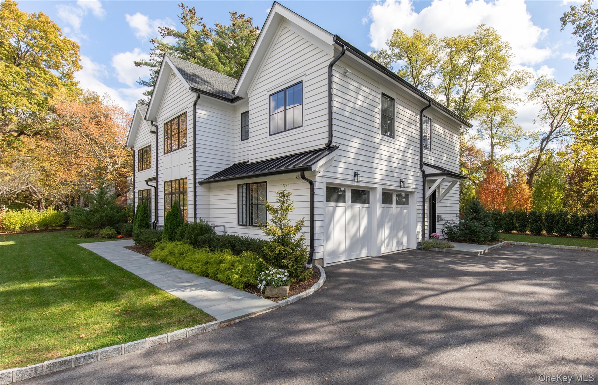 16 Myrtledale Road Scarsdale, NY 10583 - Photo 43 of 48 View of property side exterior showing the 2 car attached garage, driveway, side door to mudroom and path to front door