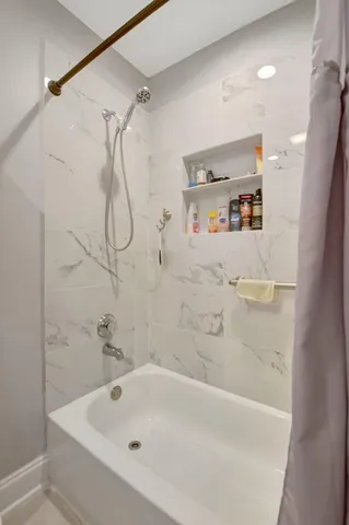 a bathroom with a bath tub with a shower