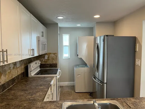 a kitchen with stainless steel appliances a refrigerator and a sink