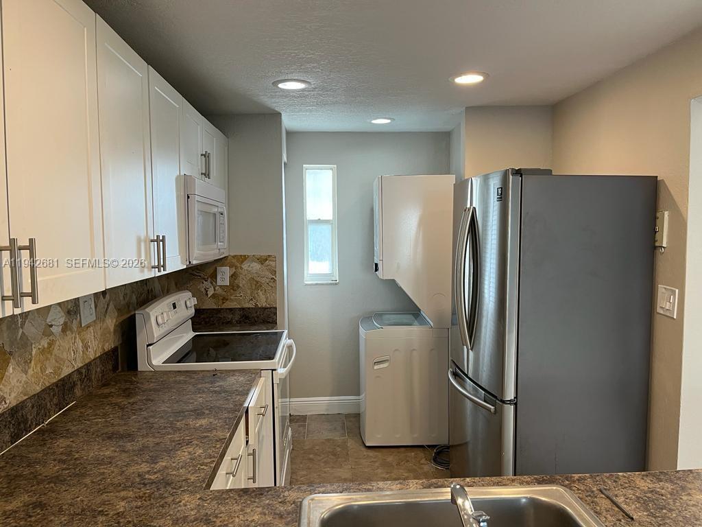 8051 South Colony Circle, Unit 109 Tamarac, FL 33321 - Photo 5 of 19 a kitchen with stainless steel appliances a refrigerator and a sink