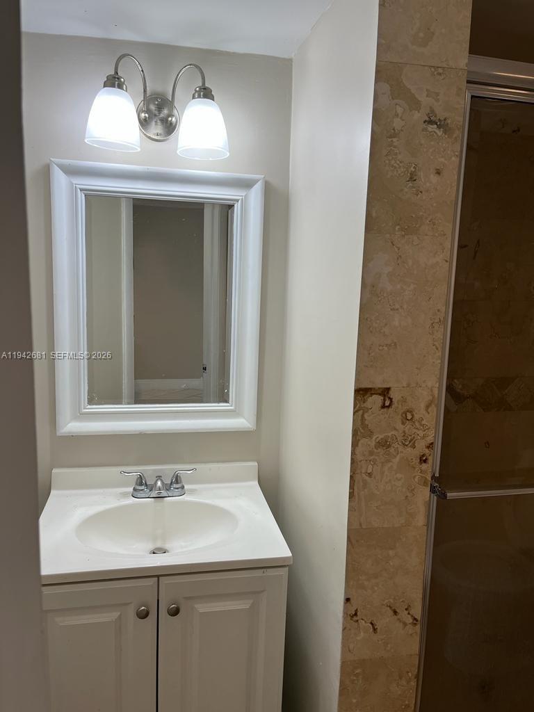 8051 South Colony Circle, Unit 109 Tamarac, FL 33321 - Photo 10 of 19 a bathroom with a sink and a mirror
