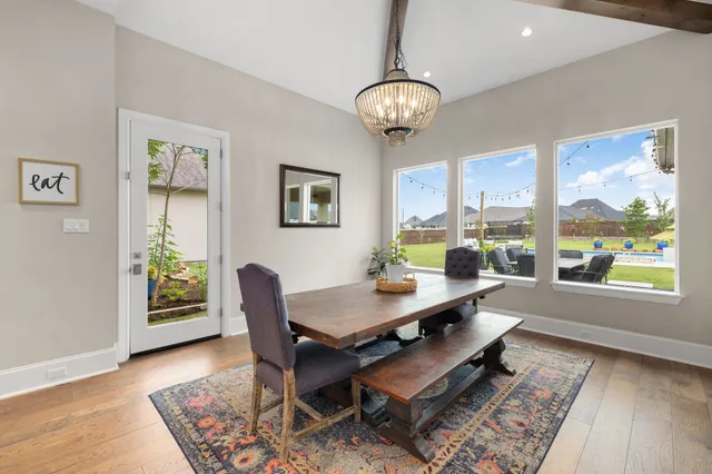 a view of a dining room with furniture a chandelier and wooden floor