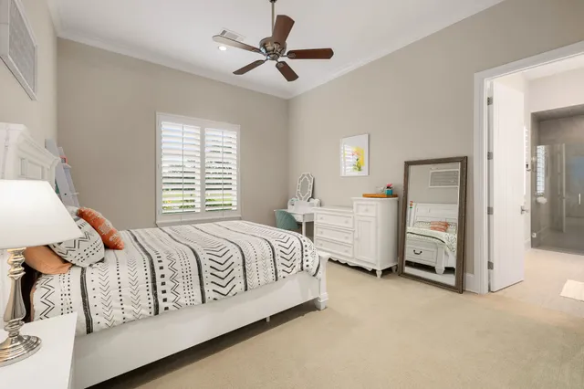 a spacious bedroom with a bed a window and a chandelier