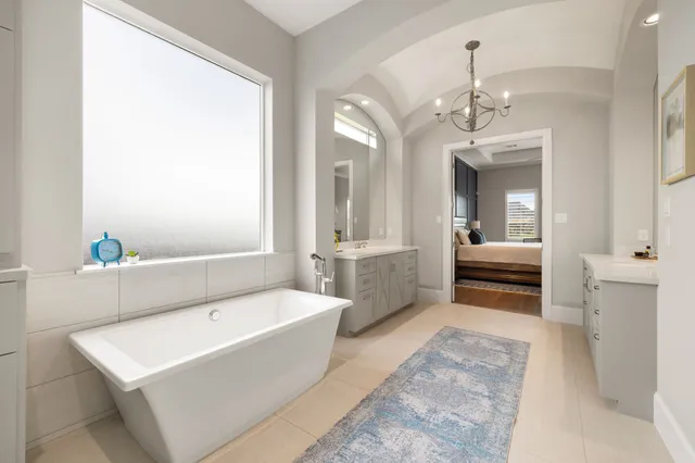 a bathroom with a tub a sink and a mirror