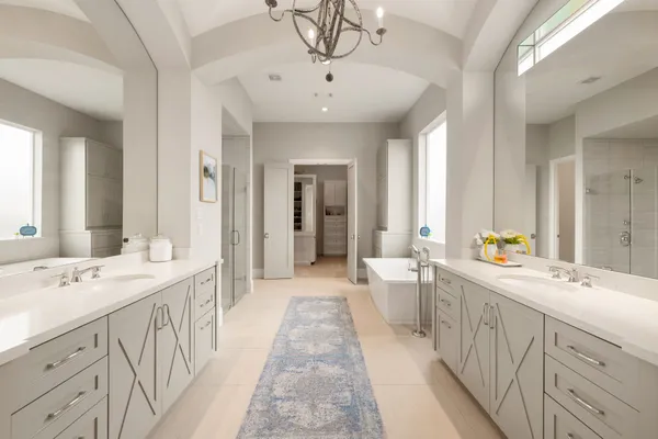 a spacious bathroom with double vanity sinks a large mirror and a shower