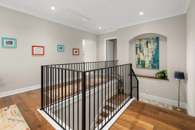 a view of a hallway with wooden floor and windows