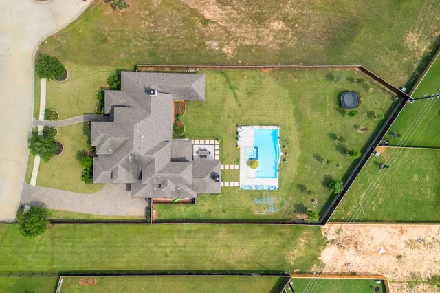 an aerial view of residential houses with outdoor space and swimming pool