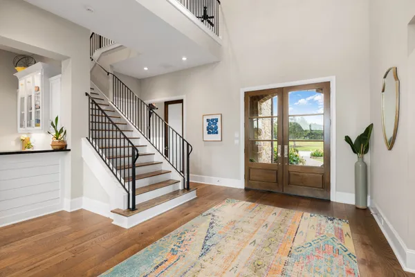 a room with lots of white furniture and a wooden floor