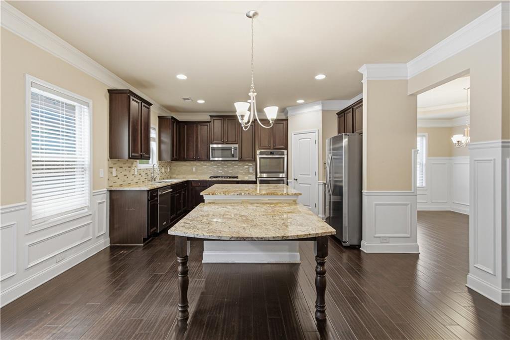 114 Madison Street Canton, GA 30115 - Photo 13 of 39 a kitchen with kitchen island a dining table chairs stainless steel appliances and cabinets