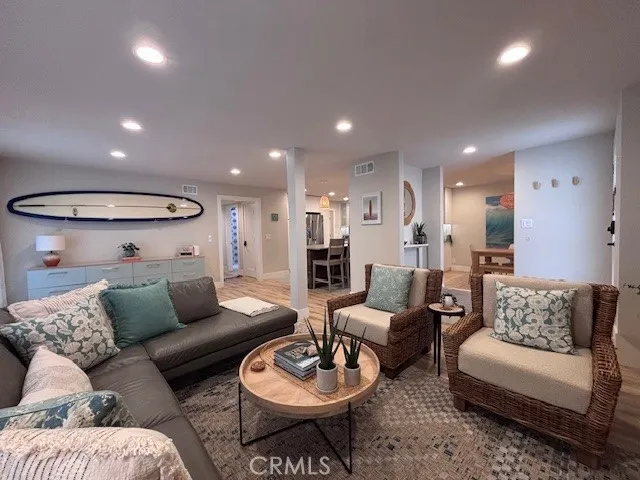 a living room with furniture and a view of kitchen
