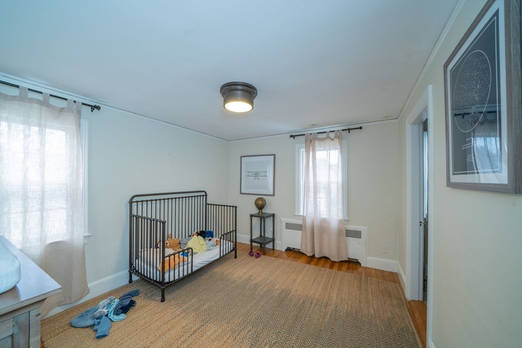 642 Centre Street Newton, MA 02458 - Photo 19 of 37 a view of a bedroom with wooden floor and windows