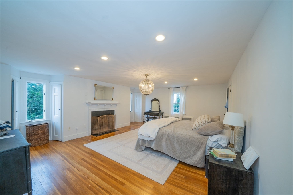 642 Centre Street Newton, MA 02458 - Photo 21 of 37 a large bedroom with a bed and a fireplace