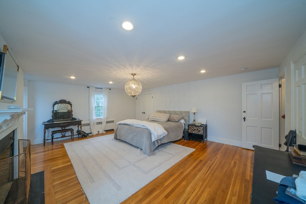 642 Centre Street Newton, MA 02458 - Photo 22 of 37 a spacious bedroom with a bed and wooden floor