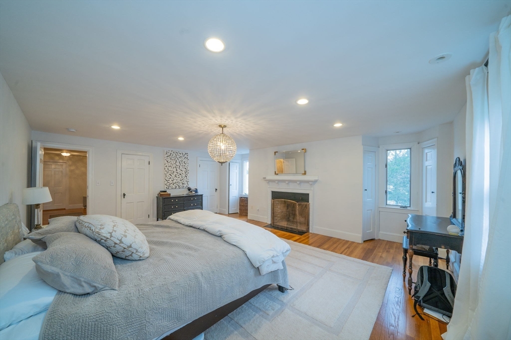 642 Centre Street Newton, MA 02458 - Photo 23 of 37 a spacious bedroom with a large bed and a fireplace