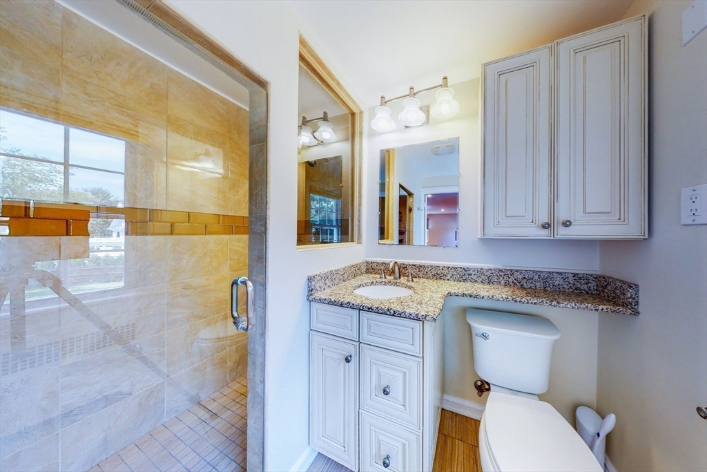 642 Centre Street Newton, MA 02458 - Photo 24 of 37 a bathroom with a granite countertop sink and a mirror