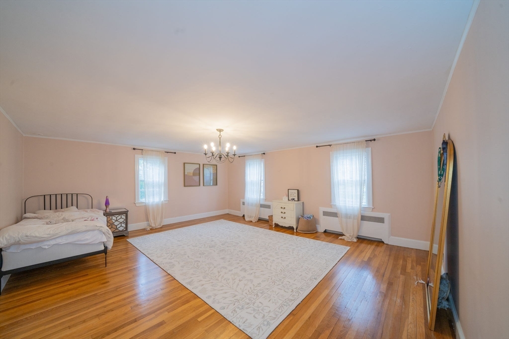642 Centre Street Newton, MA 02458 - Photo 25 of 37 a spacious bedroom with a bed and wooden floor