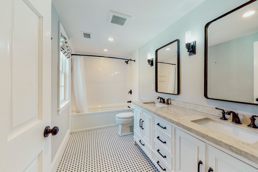 642 Centre Street Newton, MA 02458 - Photo 30 of 37 a bathroom with a granite countertop sink toilet a large mirror a shower and a bathtub