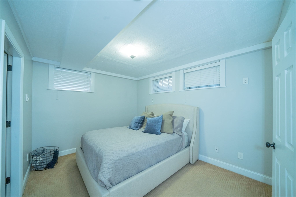 642 Centre Street Newton, MA 02458 - Photo 32 of 37 a bedroom with a bed and a wall painting