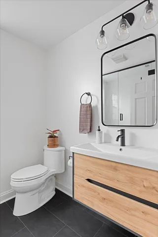 a bathroom with a toilet sink and mirror