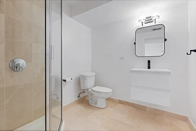 a bathroom with a toilet sink and mirror